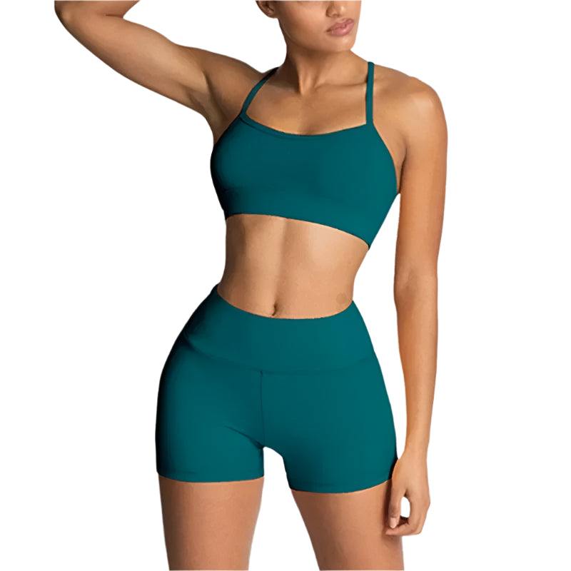 Person wearing a teal sports bra and shorts set on a light gray background
