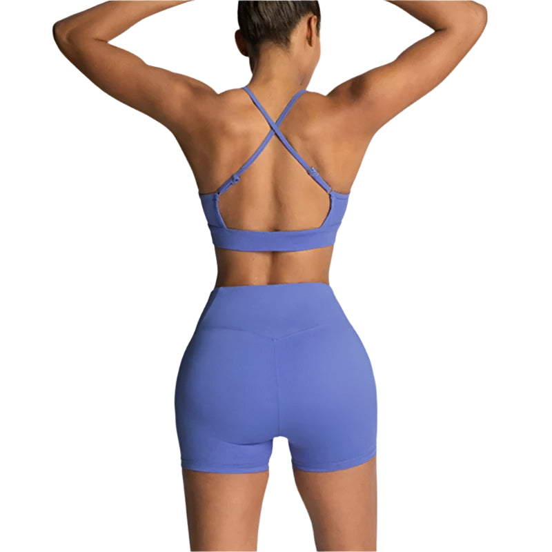 Person wearing a blue sports bra and shorts set on a light gray background