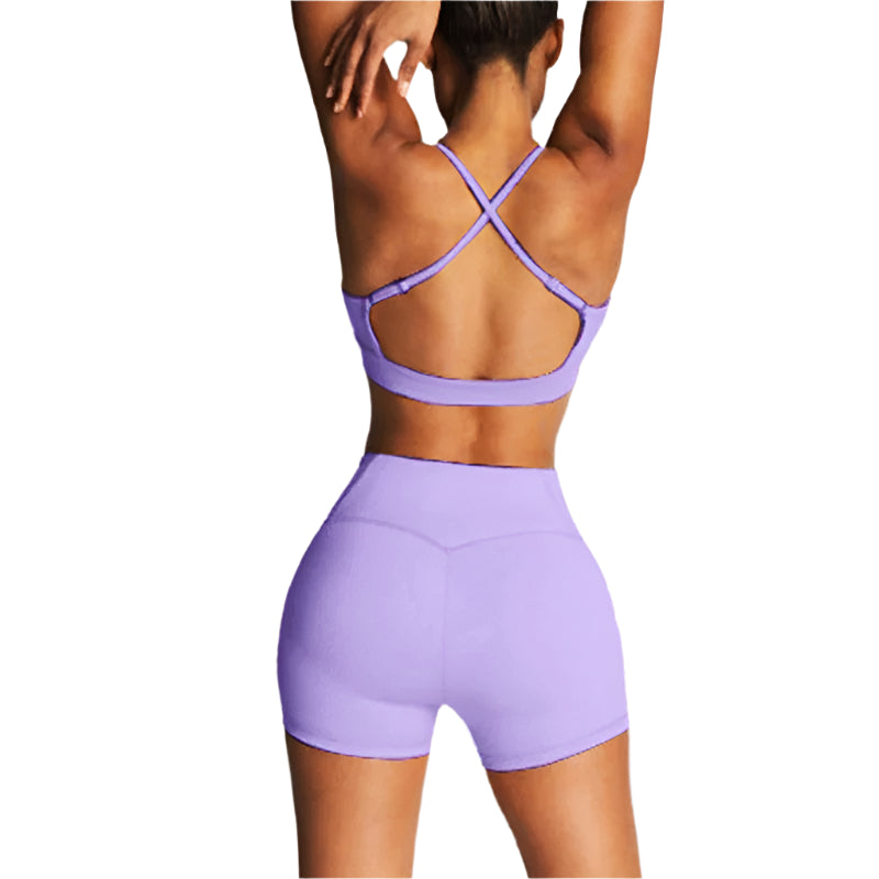 Person wearing a purple sports bra and shorts set on a light gray background