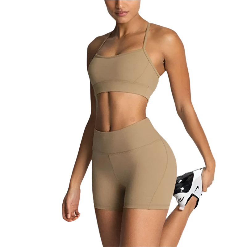 Woman wearing a beige sports bra and shorts on a white background