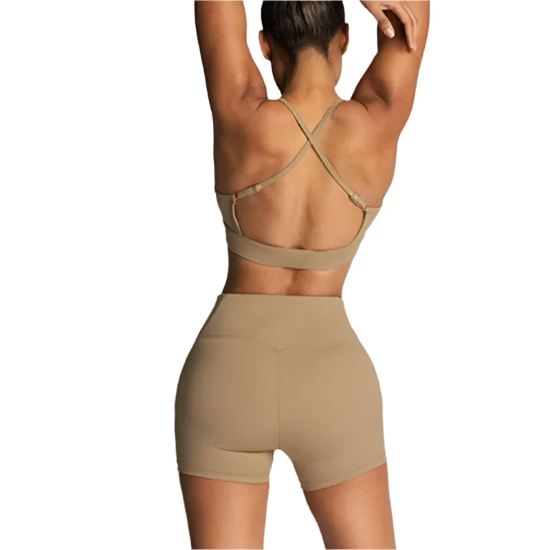 Person wearing a beige sports bra and shorts set on a light gray background