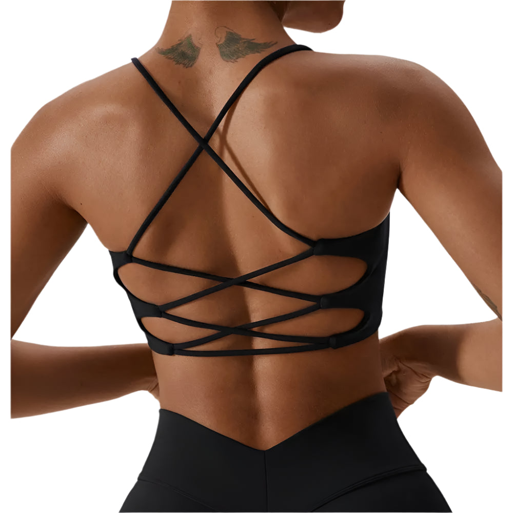Person wearing a black strappy top with a neutral background