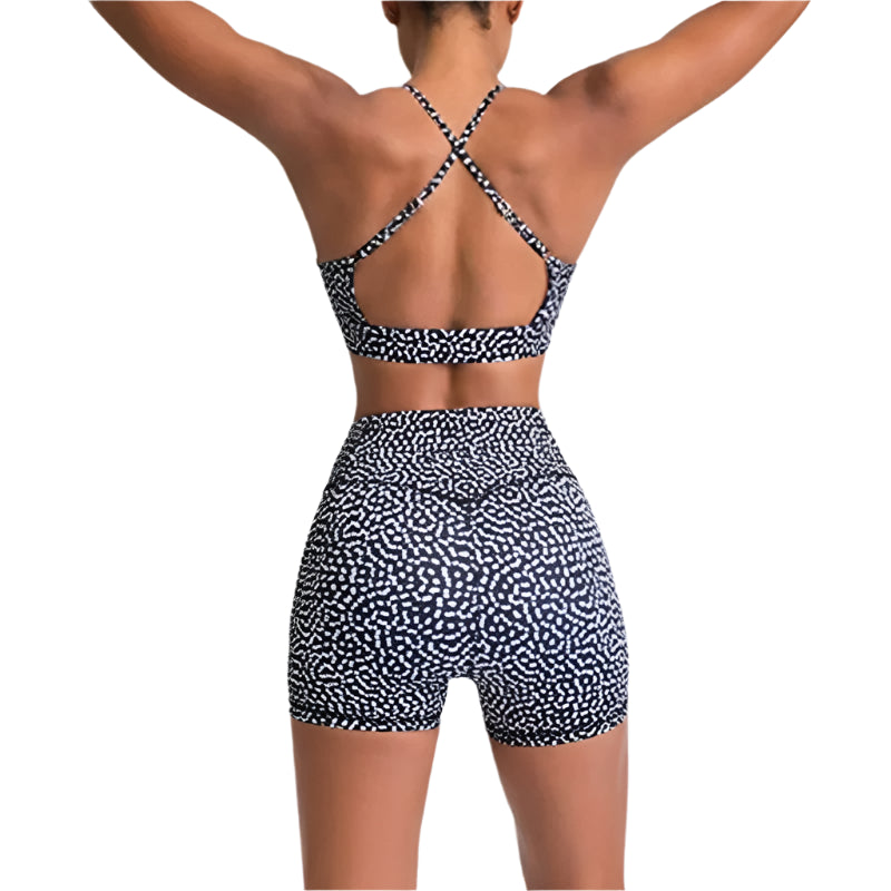 Person wearing a black and white patterned sports bra and shorts on a light gray background