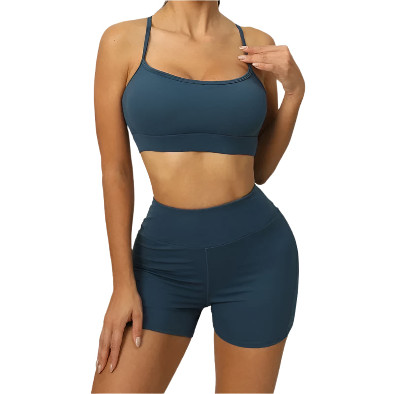 Person wearing a blue sports bra and shorts set on a neutral background